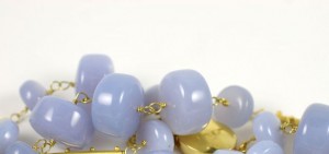 A close up of some blue beads on a white surface
