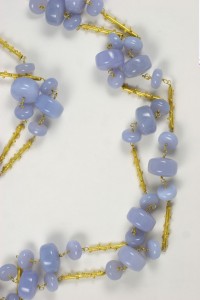 A necklace made of blue beads and gold chains.