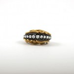 A gold and silver ring with pearls on it.