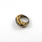 A black and gold ring with some white stones