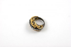 A black and gold ring with some white stones