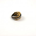 A gold and black ring with white stones on it.