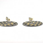 A pair of earrings with gold and black diamonds.