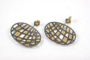 A pair of earrings with gold and black diamonds.