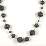 A black bead necklace with gold accents.