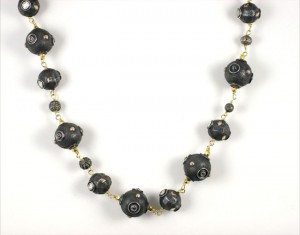 A black bead necklace with gold accents.