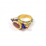 A gold ring with a purple stone on it.