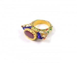A gold ring with a purple stone on it.