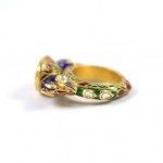 A gold ring with a green and red background