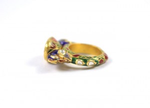 A gold ring with a green and red background