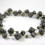 A black bead necklace with gold accents.