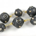 A close up of a necklace with black beads