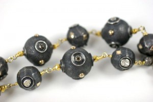 A close up of a necklace with black beads