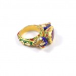 A gold ring with a purple stone on it's side.