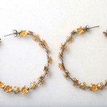 A pair of earrings with yellow beads and silver wire.