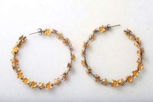 A pair of earrings with yellow beads and silver wire.