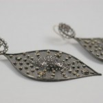 A pair of earrings with metal shapes and studs.