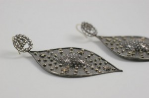 A pair of earrings with metal shapes and studs.