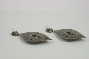 A pair of earrings made from metal and glass.