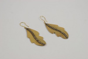 A pair of earrings with gold leaf and black diamond accents.