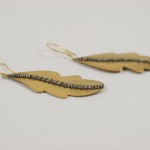 A pair of earrings made from brass and wire.