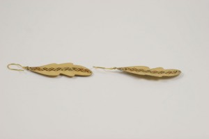 A pair of wooden feathers with a chain on them.