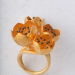 A gold ring with three flowers on it.