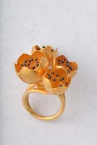 A gold ring with three flowers on it.