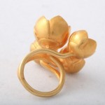 A gold ring with four flowers on it