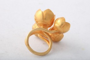 A gold ring with four flowers on it