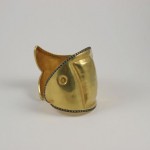 A gold cuff with a fish design on it.