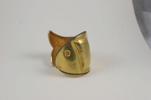 A gold cuff with a fish design on it.