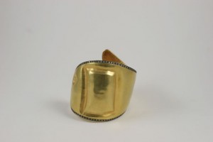 A gold bracelet with black and white stones.
