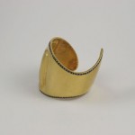 A gold cuff with black and white stones on it.