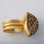 A gold ring with a large diamond on it's side.