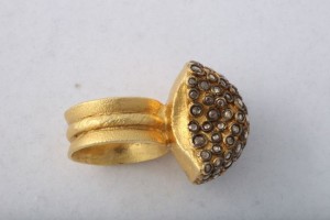 A gold ring with a large diamond on it's side.