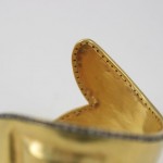 A close up of the side of a gold shoe