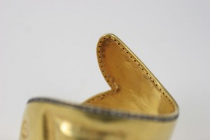 A close up of the side of a gold shoe