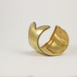 A gold cuff with a diamond on it.