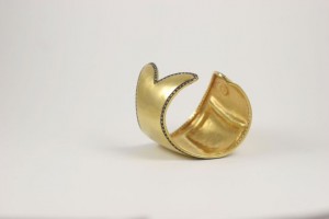 A gold cuff with a diamond on it.