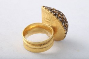 A gold ring with a diamond on it's side.
