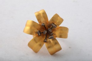 A gold flower with six petals and two small spikes.