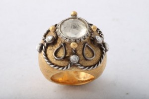 A gold ring with a white stone on top of it.