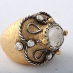 A gold ring with a white stone on top of it.