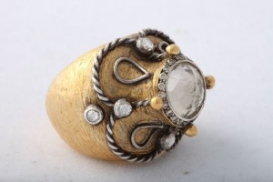 A gold ring with a white stone on top of it.