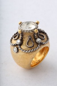 A gold ring with a clock on it