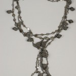 A long necklace with many small silver pieces.