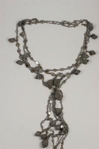 A long necklace with many small silver pieces.