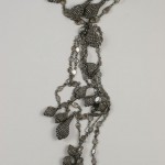 A long necklace with many small silver beads.