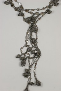 A long necklace with many small silver beads.